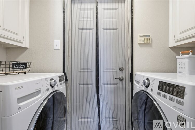 A laundry room with two washing machines and a door.