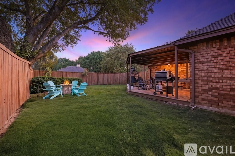 A backyard with a wooden fence and a patio area.