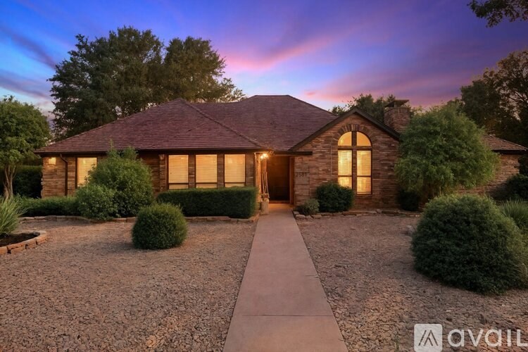 A house with a front yard and a pathway leading to the front door.