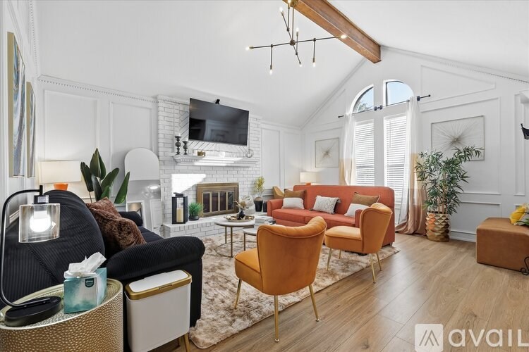A living room with a black chair and a white couch.
