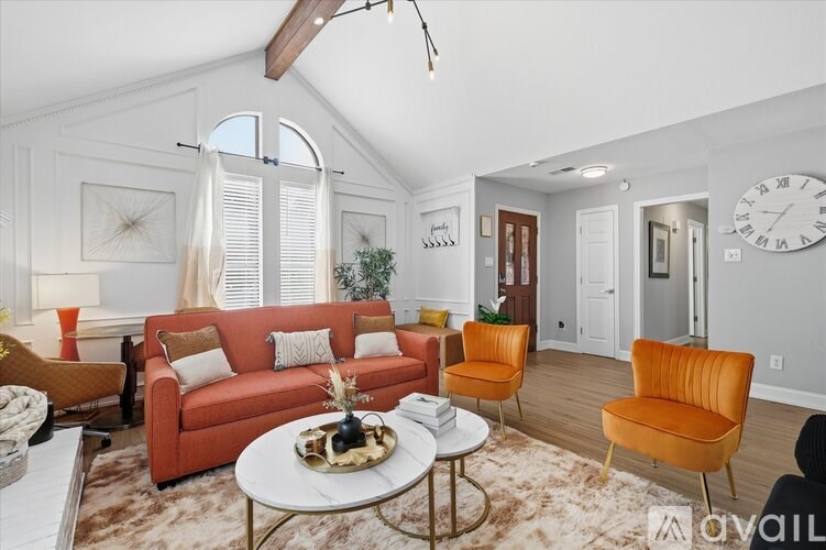 A living room with a red couch and a white coffee table.