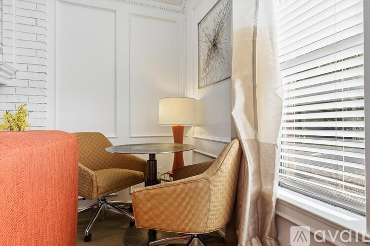 A room with a table, chairs and a lamp.