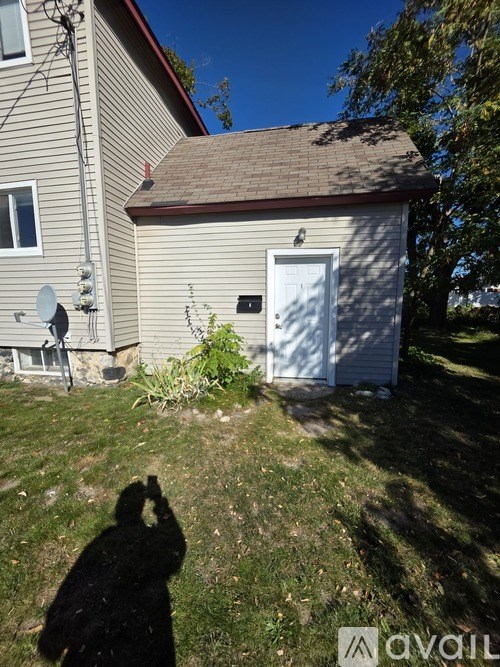 A person is taking a photo of a house with a white door and a satellite dish.