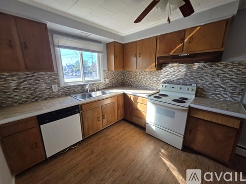 A kitchen with wooden cabinets and a white stove top oven.