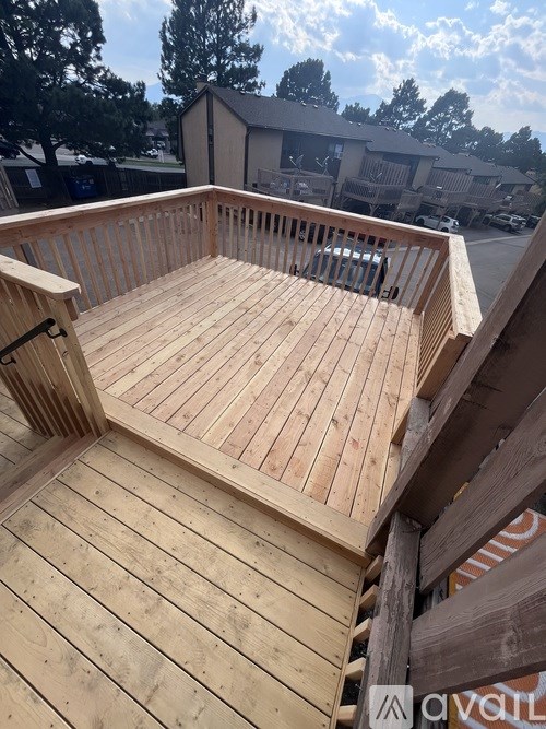 A wooden deck with a railing and a bench.