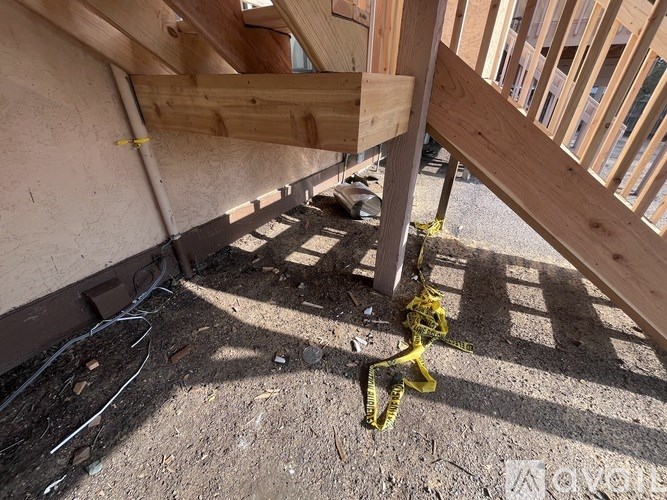 A wooden beam is supported by a concrete pillar.
