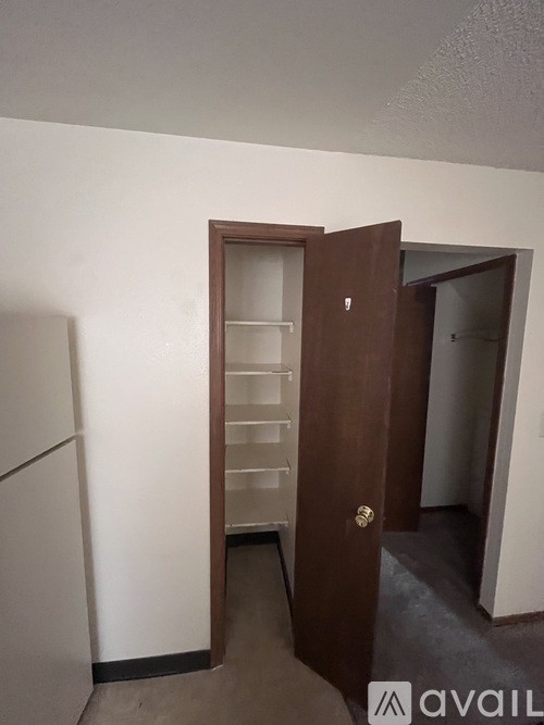 A room with a white wall and a brown door.