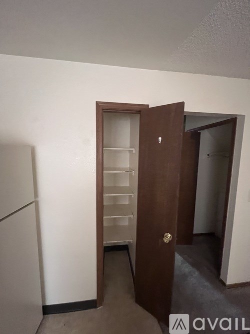 A room with a white wall and a brown door.