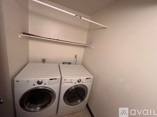 Two front load washing machines in a small laundry room.