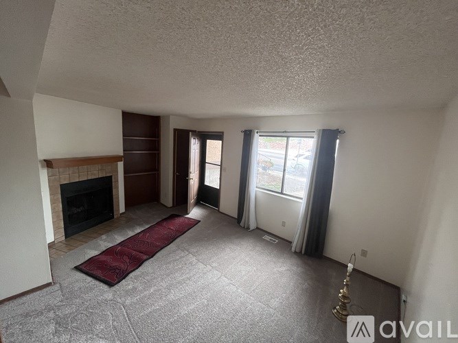 A living room with a fireplace and a carpeted area.