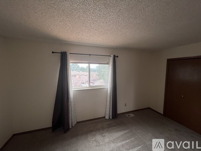 A room with a window and a carpeted floor.