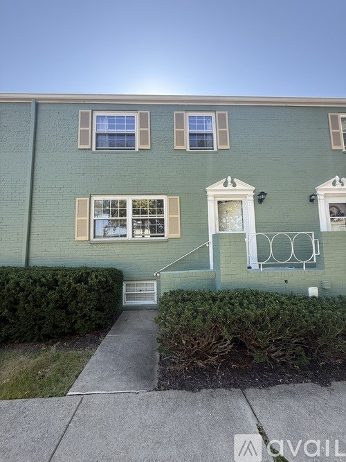 A green building with a white door and windows.