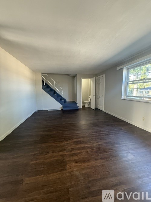 A room with wooden floors and a staircase.