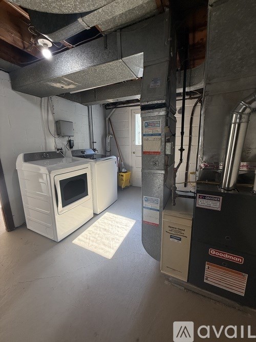 A room with a Goodman furnace and a white oven.