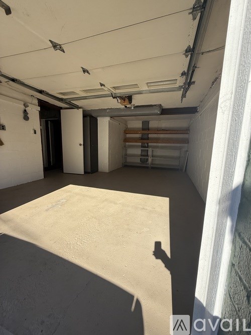 A room with a white ceiling and walls, a concrete floor, and a white curtain on the right side.