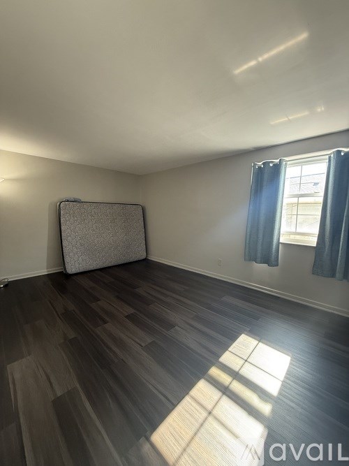 A room with a grey carpet and wooden flooring.