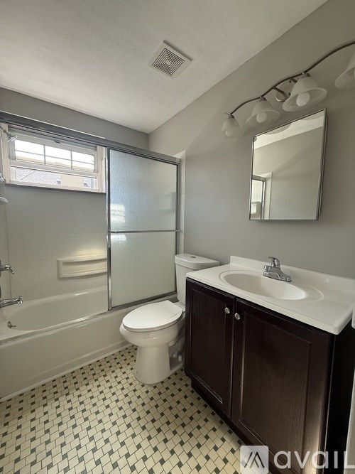 A bathroom with a toilet, sink, and shower.