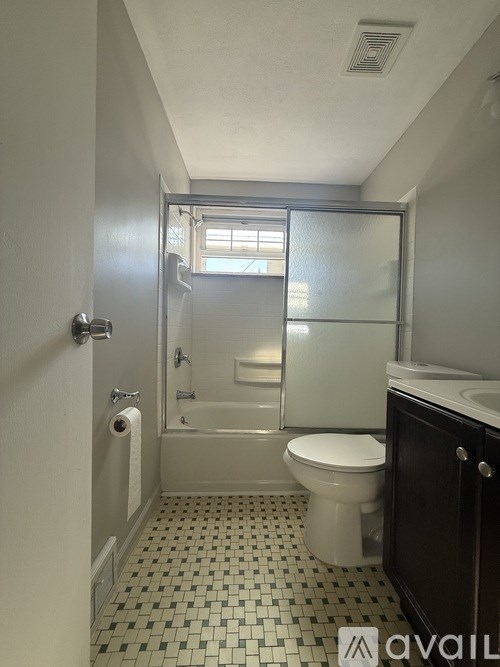 A bathroom with a toilet, sink, and shower.