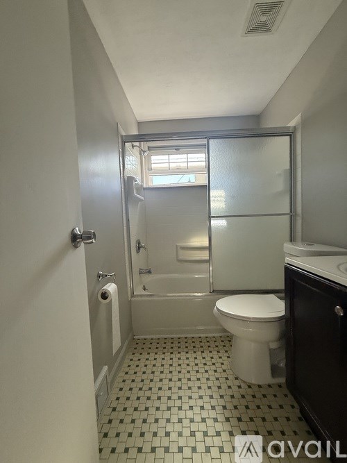 A bathroom with a toilet, sink, and shower.