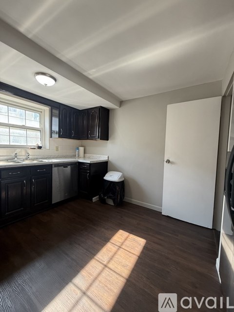 A kitchen with dark wood cabinets and a white door.