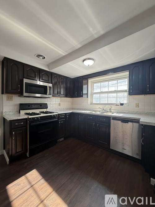A kitchen with black cabinets and a white countertop.