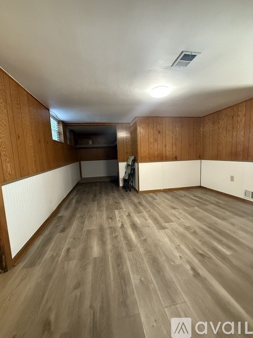 A room with wooden walls and a grey floor.