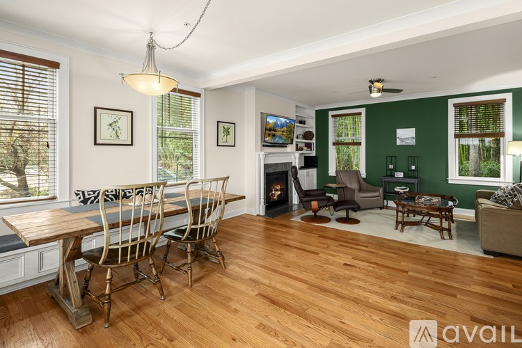A living room with a fireplace and wooden floors.