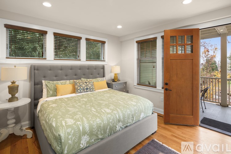 A bedroom with a large bed and a wooden door leading to a balcony.