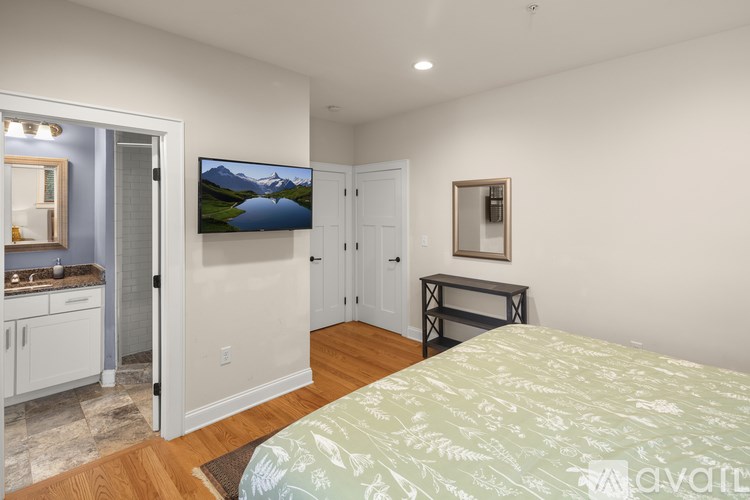 A bedroom with a bed, a television, and a small table.