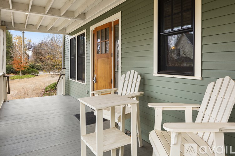 A porch with two chairs and a table.
