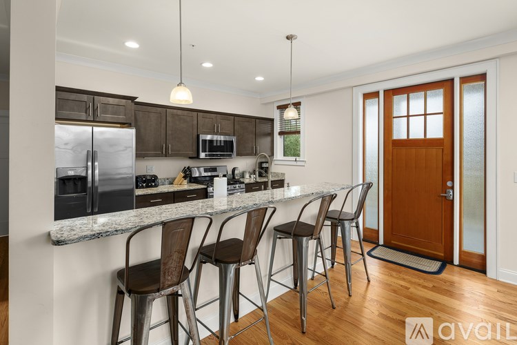 A kitchen with a bar area and chairs.