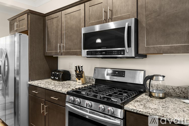 A modern kitchen with a stainless steel refrigerator, microwave, and stove.