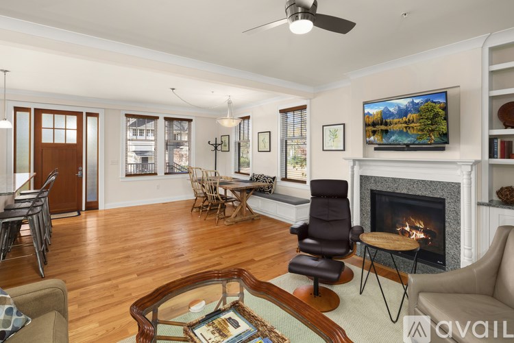 A living room with a fireplace and a television on the wall.