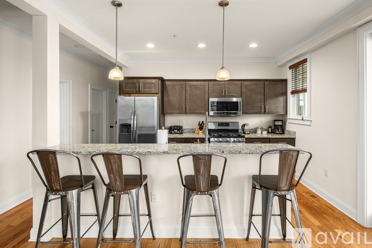 A kitchen with a bar area and four chairs.