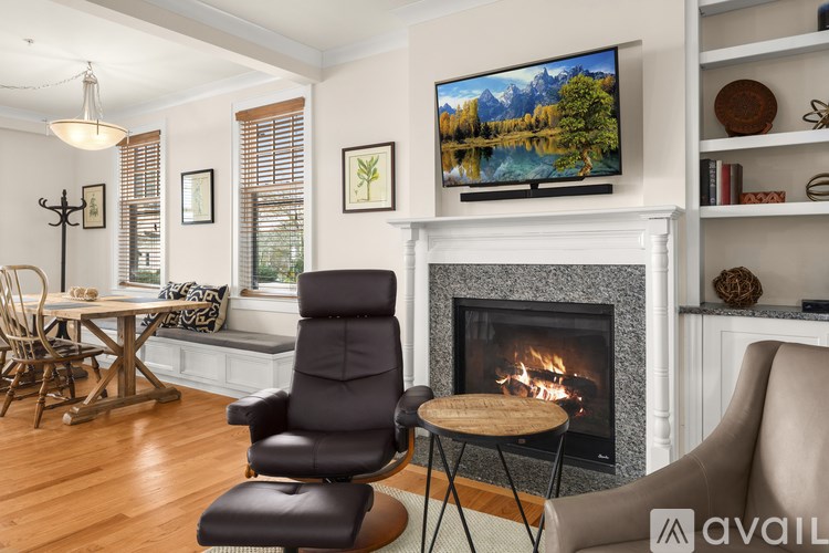 A living room with a fireplace and a television on the wall.