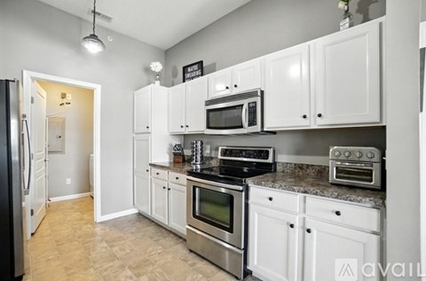 A kitchen with white cabinets and stainless steel appliances.