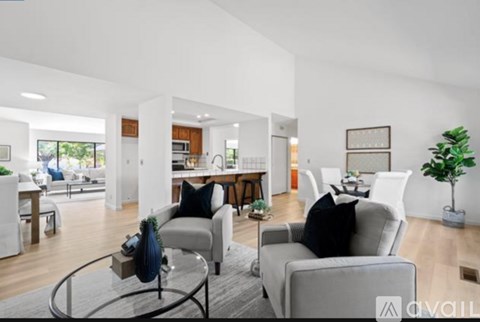 A modern living room with a grey sofa and a glass coffee table.