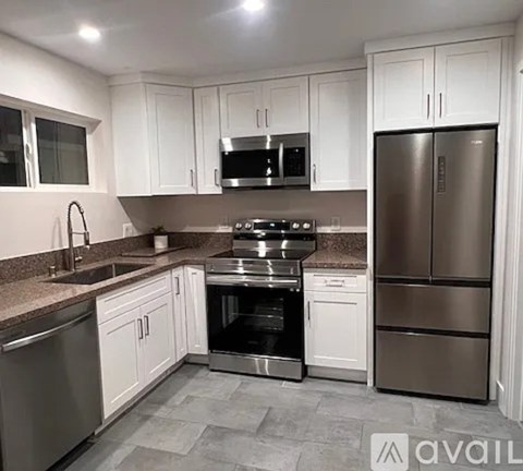 A kitchen with white cabinets and stainless steel appliances.