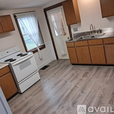 A kitchen with a white stove and wooden cabinets.