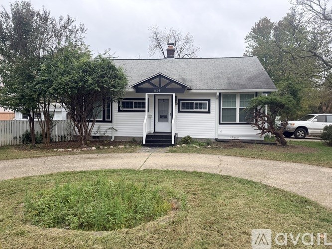 A small white house with a black door and a grey roof.