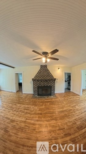 A room with a fireplace and a ceiling fan.
