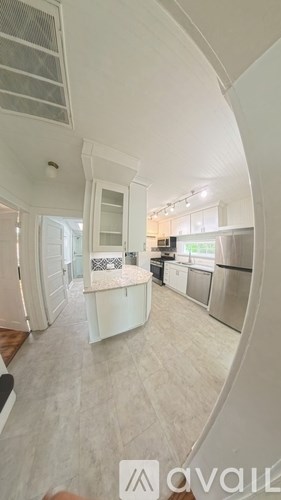 A kitchen with white cabinets and a refrigerator.