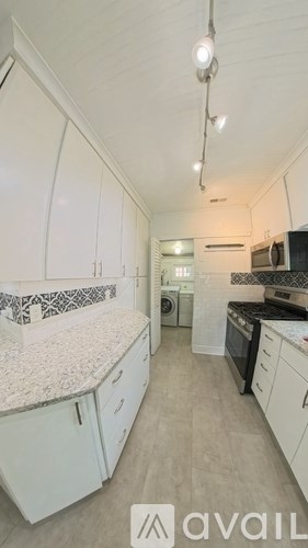 A kitchen with white cabinets and a countertop.