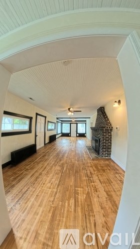 A hallway with wooden floors and white walls.