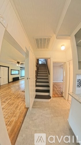 A hallway with a staircase leading to the second floor.
