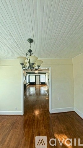 A white bathroom with a toilet, sink, and mirror.