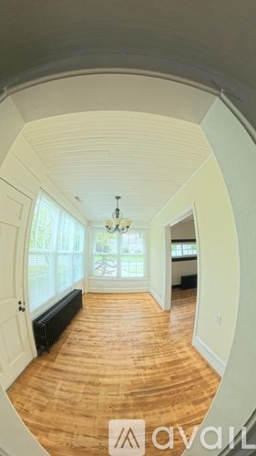 A hallway with wooden floors and white walls.