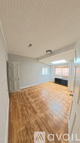 A room with wooden flooring and white walls.
