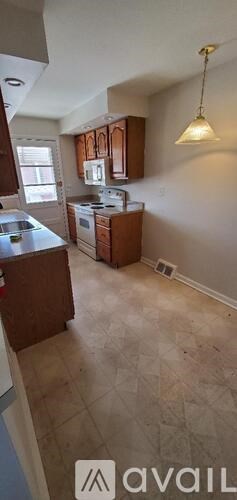 A kitchen with brown cabinets and a tiled floor.