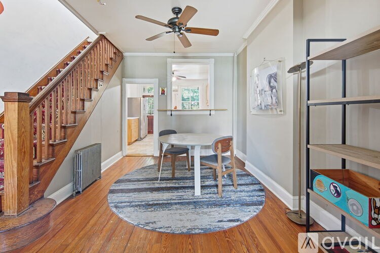 A dining table with four chairs and a bow on the table.